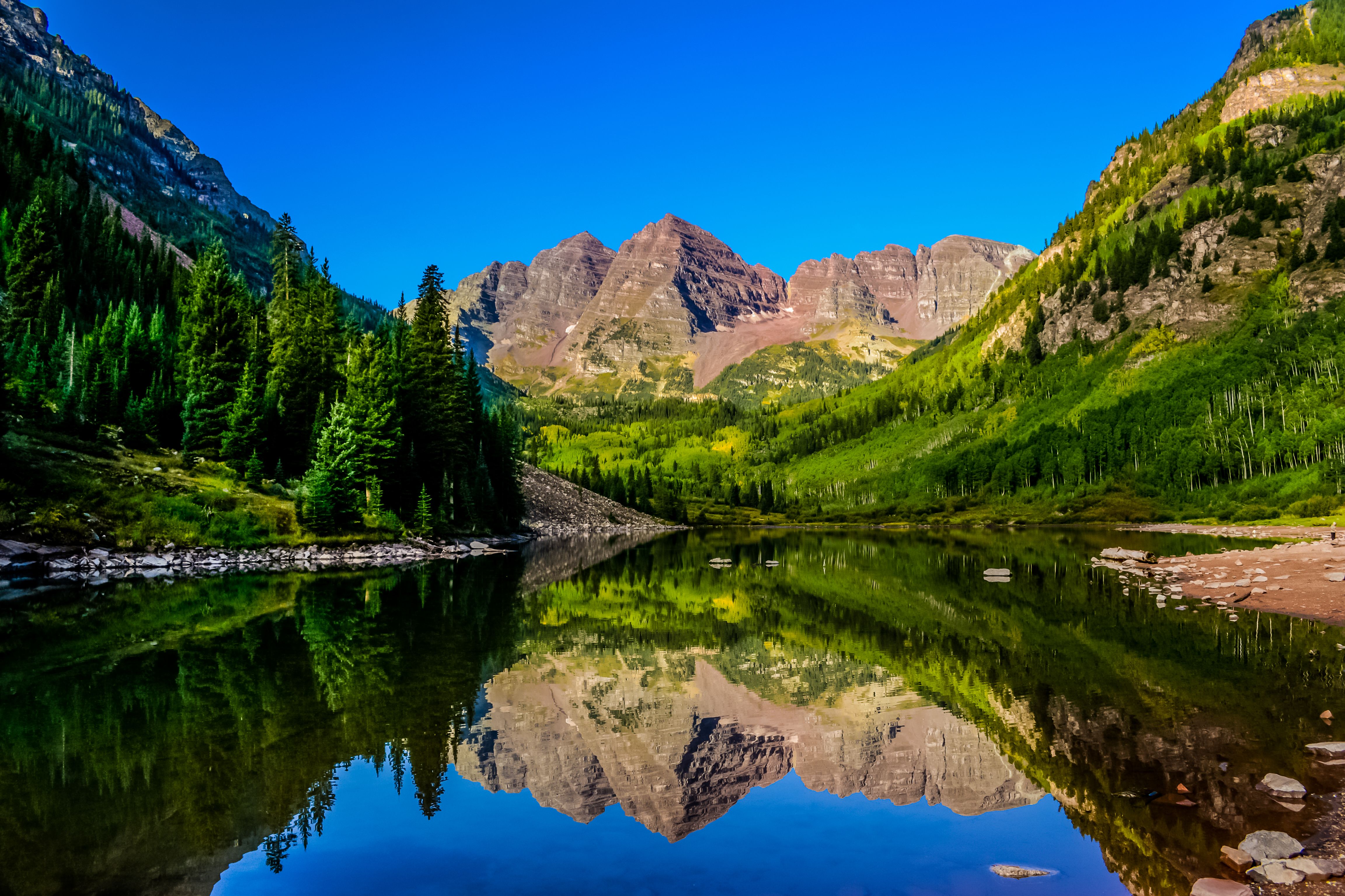 Alpine lake reflecting the Maroon Bells peaks in the Colorado high country
